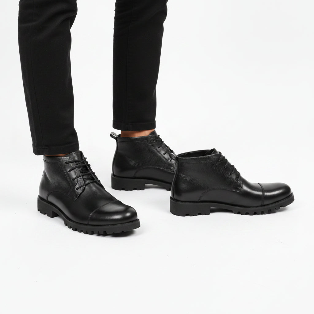 black leather ankle boots feature a cap-toe design and a thick