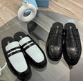 Black-and-white two-tone glossy penny loafer mules