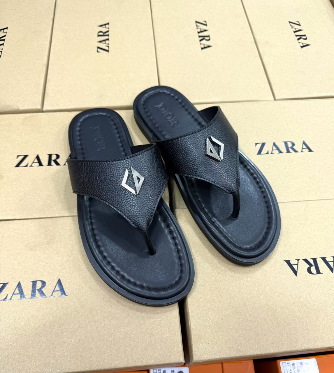Thong sandal with a silver diamond-shaped metal accent on the strap