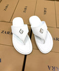 Thong sandal with a silver diamond-shaped metal accent on the strap